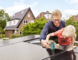 Vader en zoon bij zonnepanelen op dak